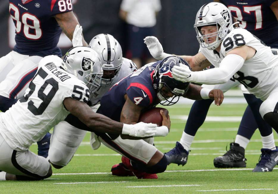 Houston Texans quarterback Deshaun Watson (4) is hit by Oakland Raiders defenders Tahir Whitehe ...
