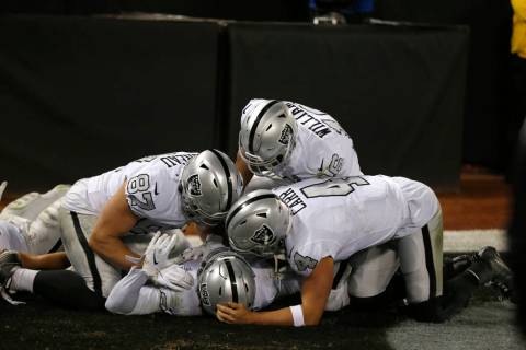 Oakland Raiders running back Josh Jacobs, bottom, celebrates with teammates after scoring again ...