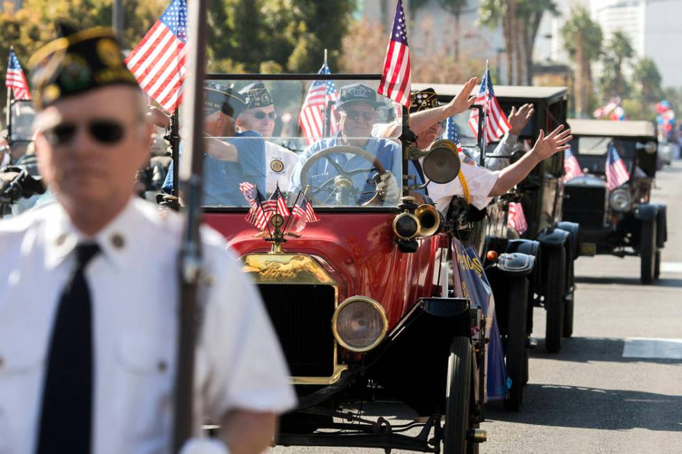 Members of American Legion Post 76 wave to the crowd on 4th Street during the 2016 Veterans Day ...