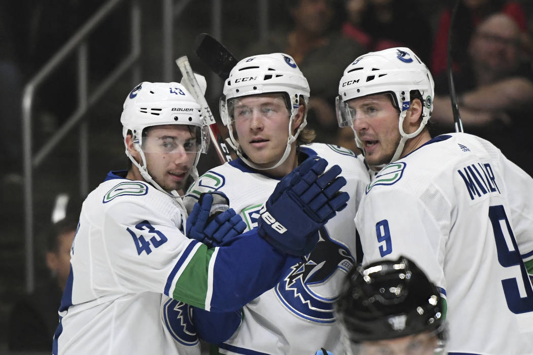 Vancouver Canucks defenseman Quinn Hughes, right wing Brock Boeser and center J.T. Miller, from ...