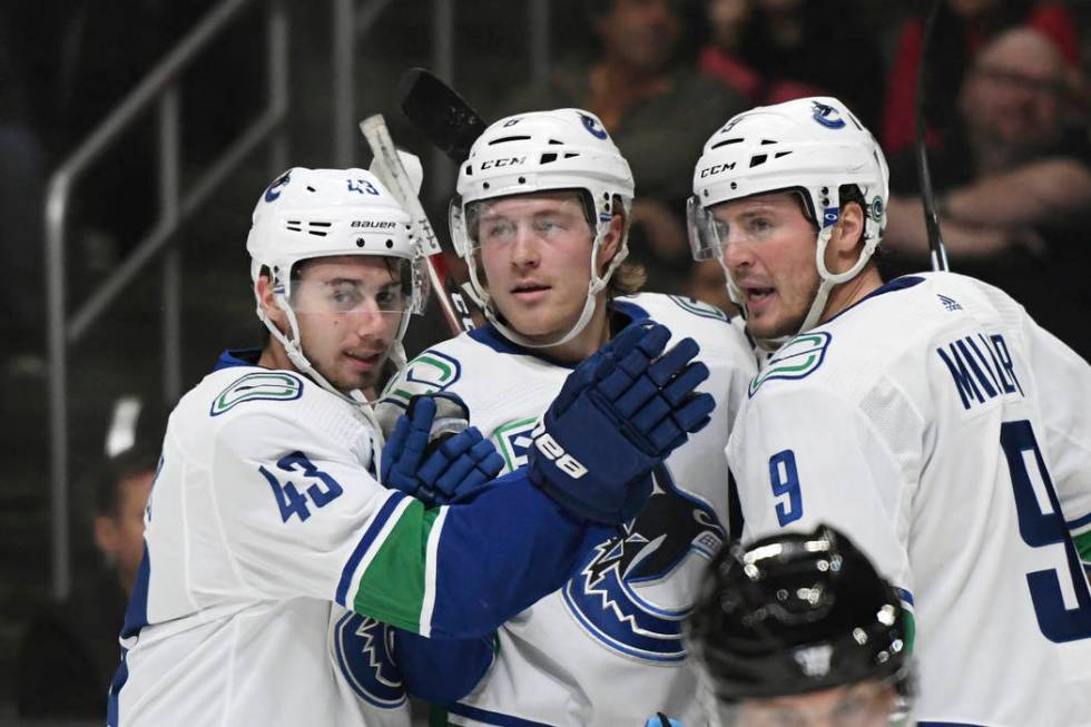 Vancouver Canucks defenseman Quinn Hughes, right wing Brock Boeser and center J.T. Miller, from ...