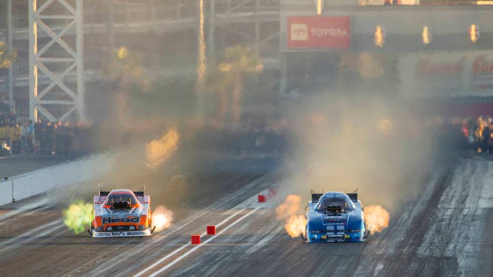 Funny car racers Jonnie Lindberg, left, and Matt Hagan battle in the final round during the Dod ...