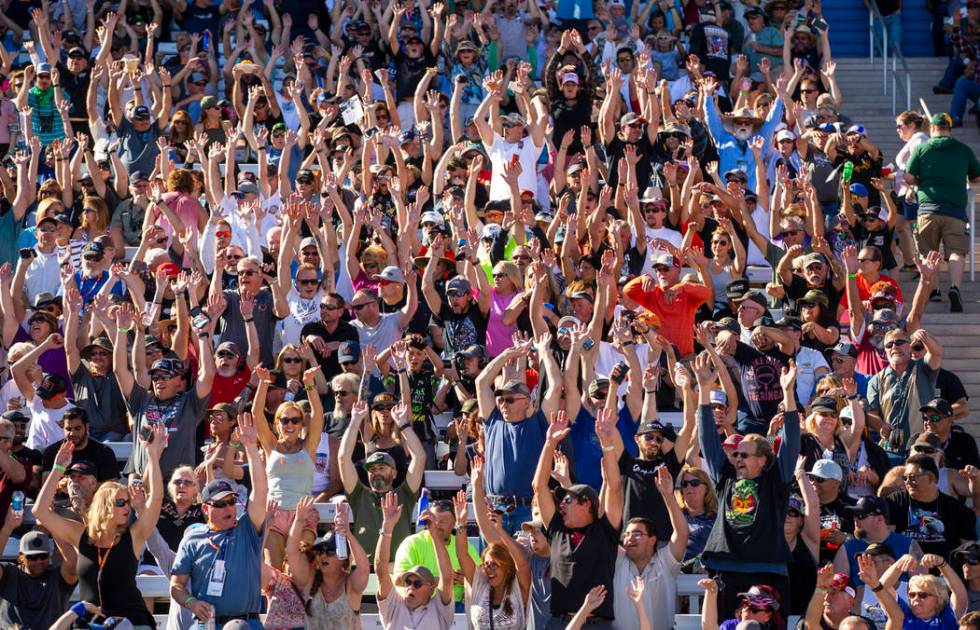 Fans stand and do the "wave" during the second round of the Dodge NHRA Nationals at t ...