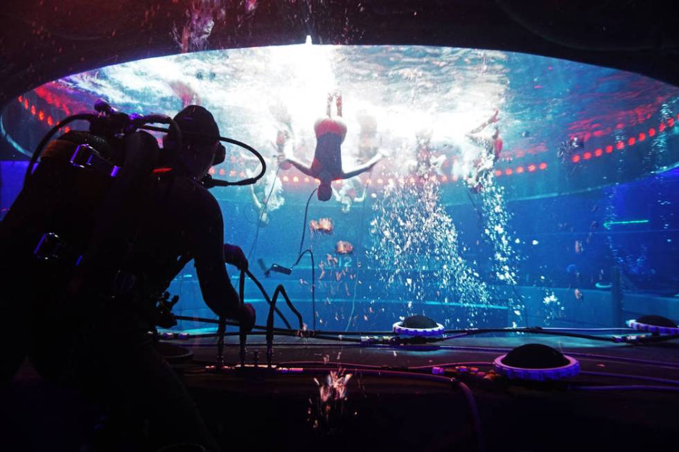 A diver technician, left, supplies oxygen to synchronized swimmers performing “Tango.” Dur ...