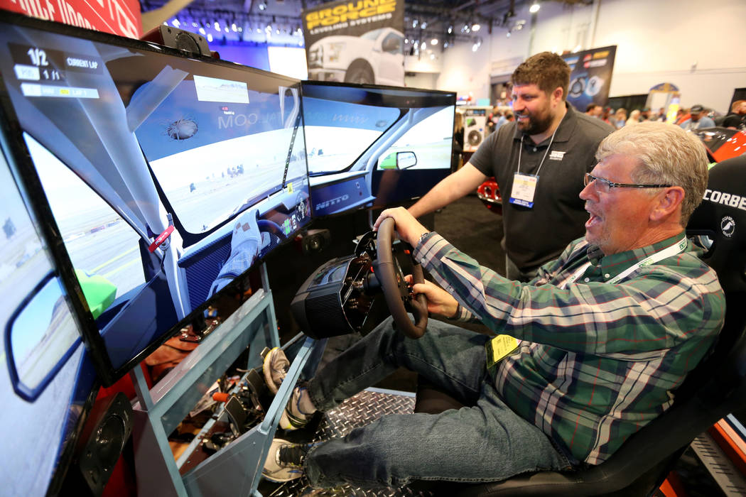 Gary Peltzer of Scottsdale, Ariz., drives a simulator with the help of Zach Davis at the Power ...