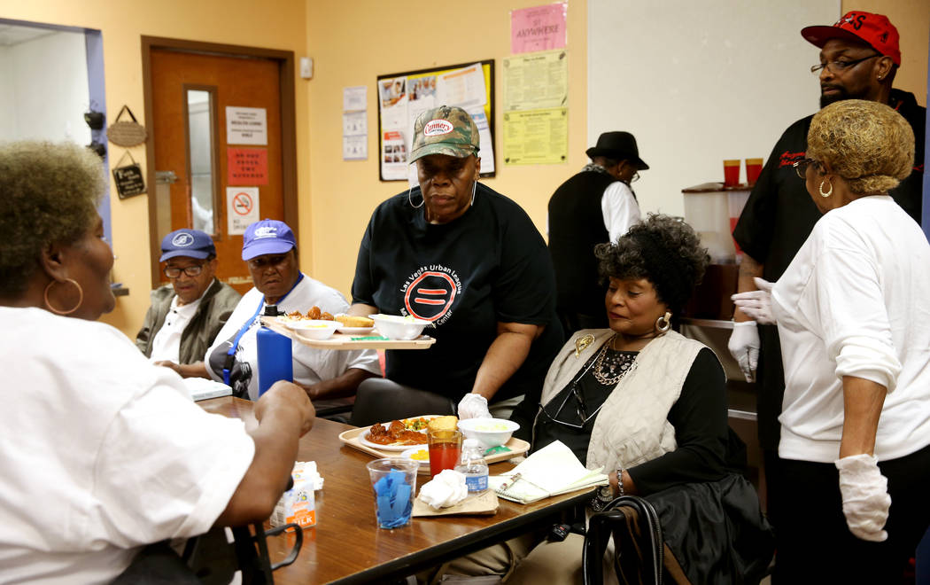 Willie Jones serves lunch to Magnolia Harper, 65, and Ada Glover, 76, at Martin Luther King Jr. ...