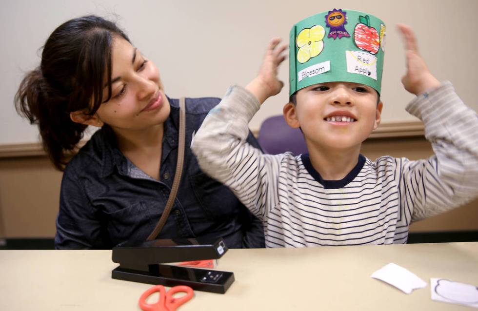 Christian Falcon, 3, dons his "life cycle hat" with his mom Berenice Falcon during a ...