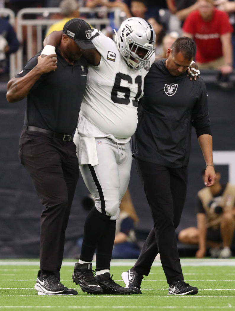 Oakland Raiders center Rodney Hudson (61) is helped off the field his trainers after sustaining ...