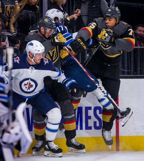 Vegas Golden Knights left wing Tomas Nosek (92) sandwich's Winnipeg Jets left wing Adam Lowry ( ...