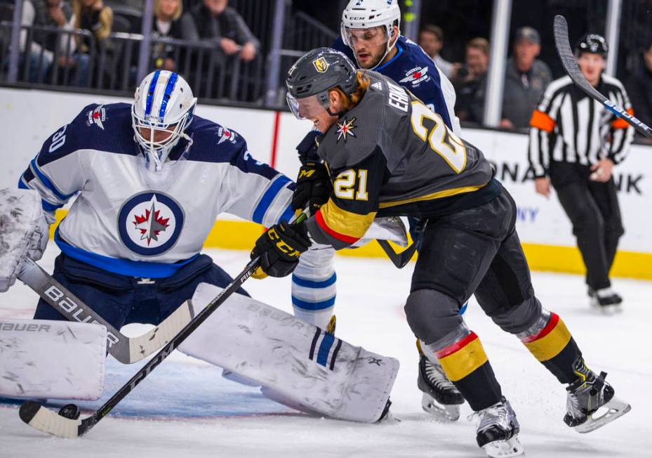 Winnipeg Jets goaltender Laurent Brossoit (30) gets a pad on a shot by Vegas Golden Knights cen ...