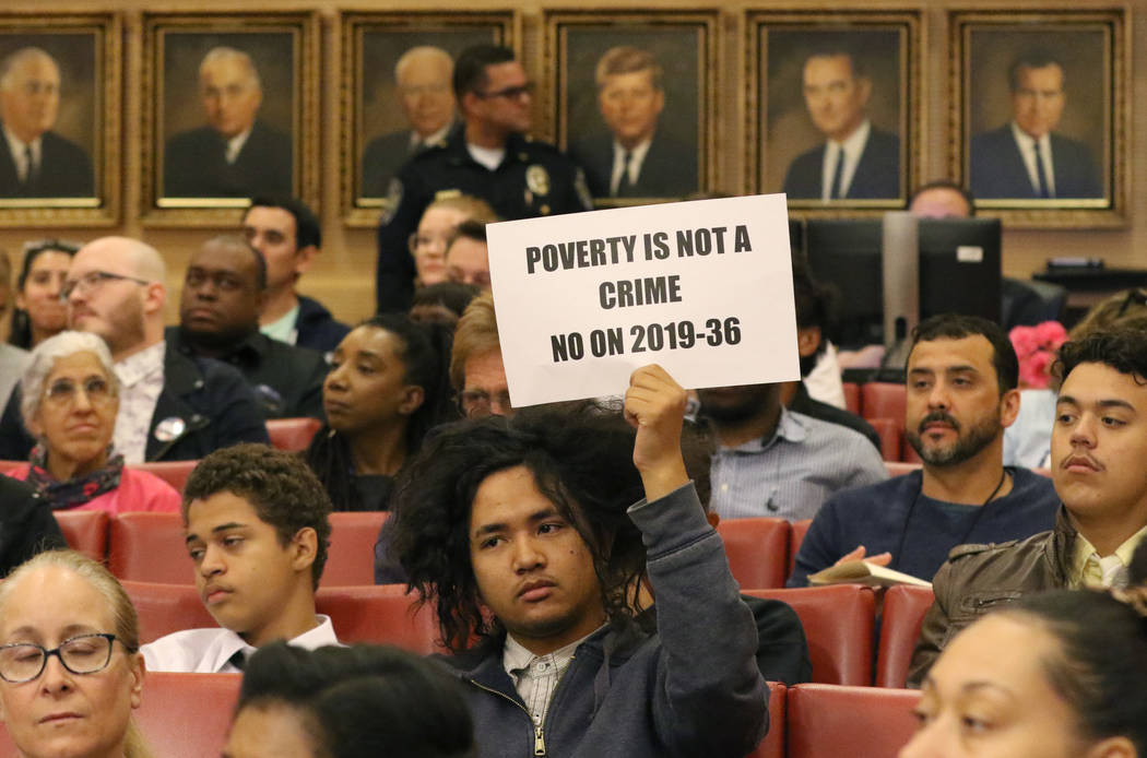 Rudolf Jovero of Las Vegas holds a sign inside council chambers during a protest against the ci ...