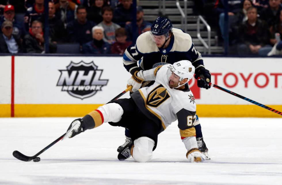 Vegas Golden Knights forward Max Pacioretty falls in front of Columbus Blue Jackets forward Jos ...