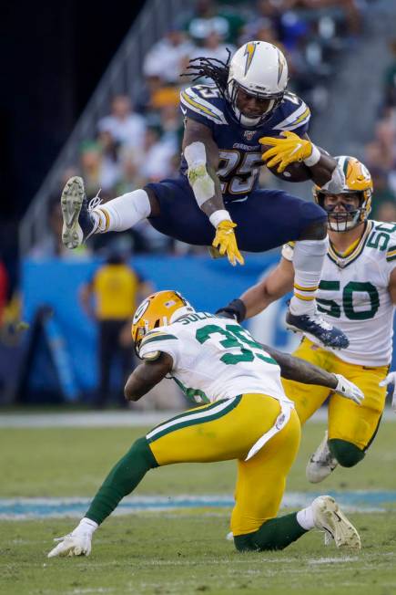 Los Angeles Chargers running back Melvin Gordon jumps over Green Bay Packers defensive back Cha ...