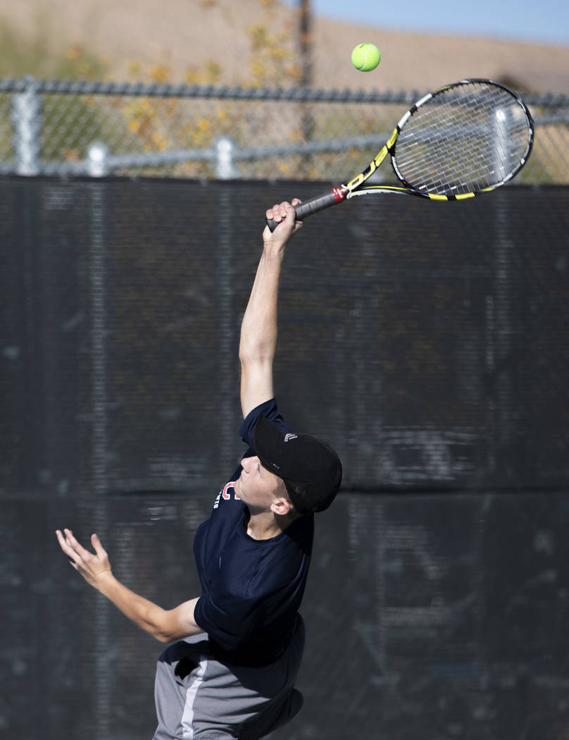 Coronado High School's Jonah Blake serves during a doubles match with his partner Jason Michael ...