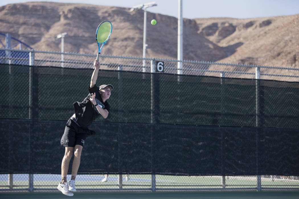 Palo Verde High School's Benjamin Waid jumps to serve during a doubles match with his partner W ...