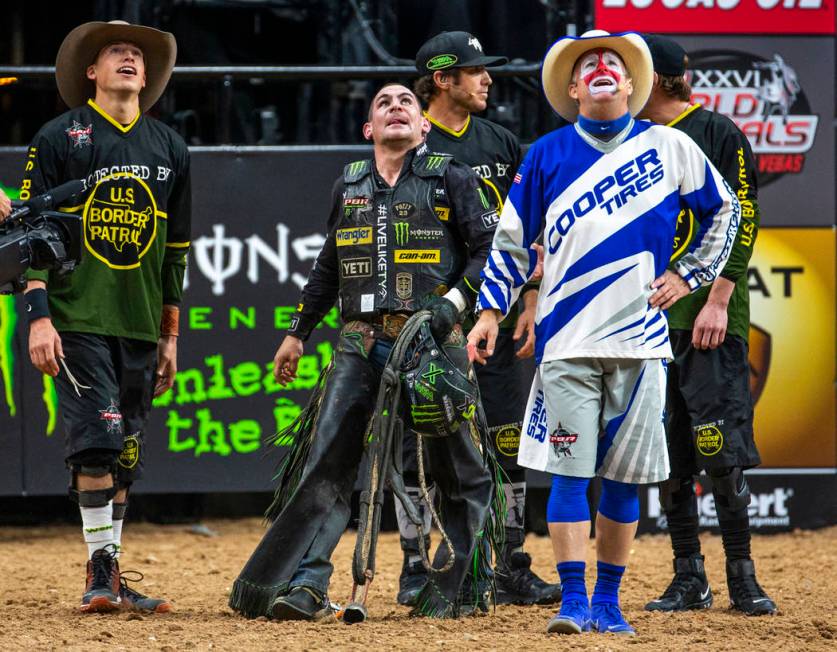 Chase Outlaw, center, watches the replay above to see he rode the eight seconds needed atop of ...