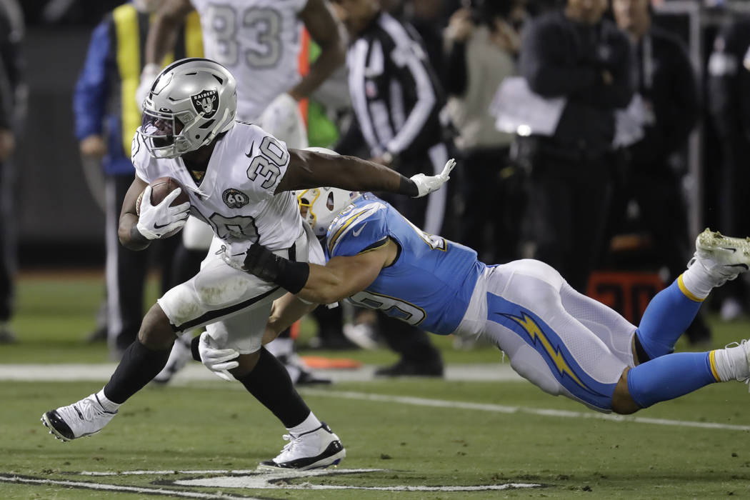 Oakland Raiders running back Jalen Richard (30) runs against Los Angeles Chargers linebacker Dr ...