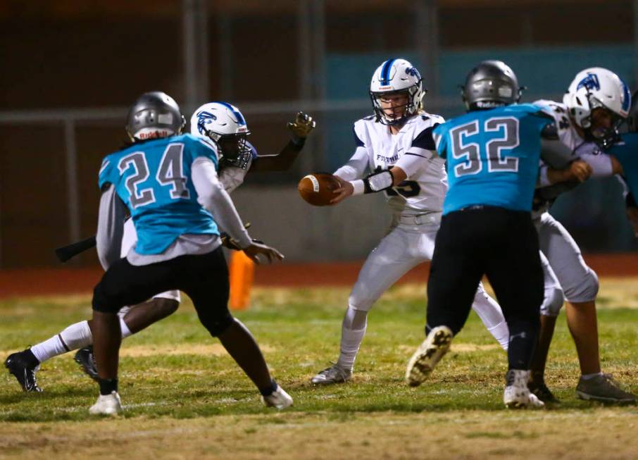 Foothill quarterback Koy Riggin (15) hands the ball off to Foothill's Kendric Thomas (2) during ...