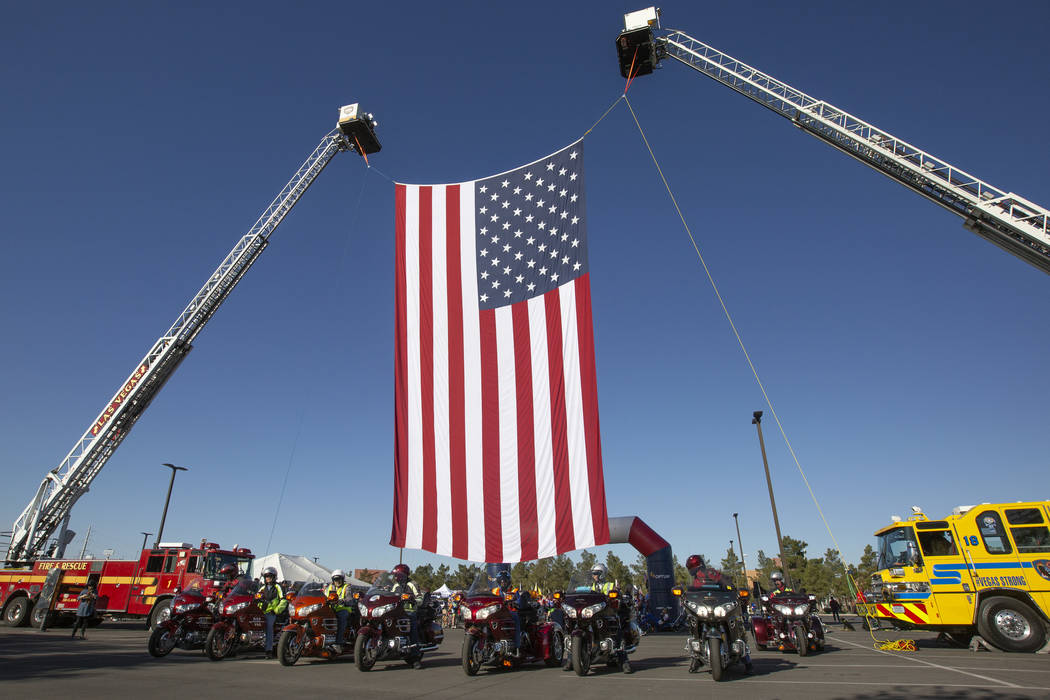 The American flag is hung for Las Vegas Honor Ride participants to ride under on Saturday, Nov. ...