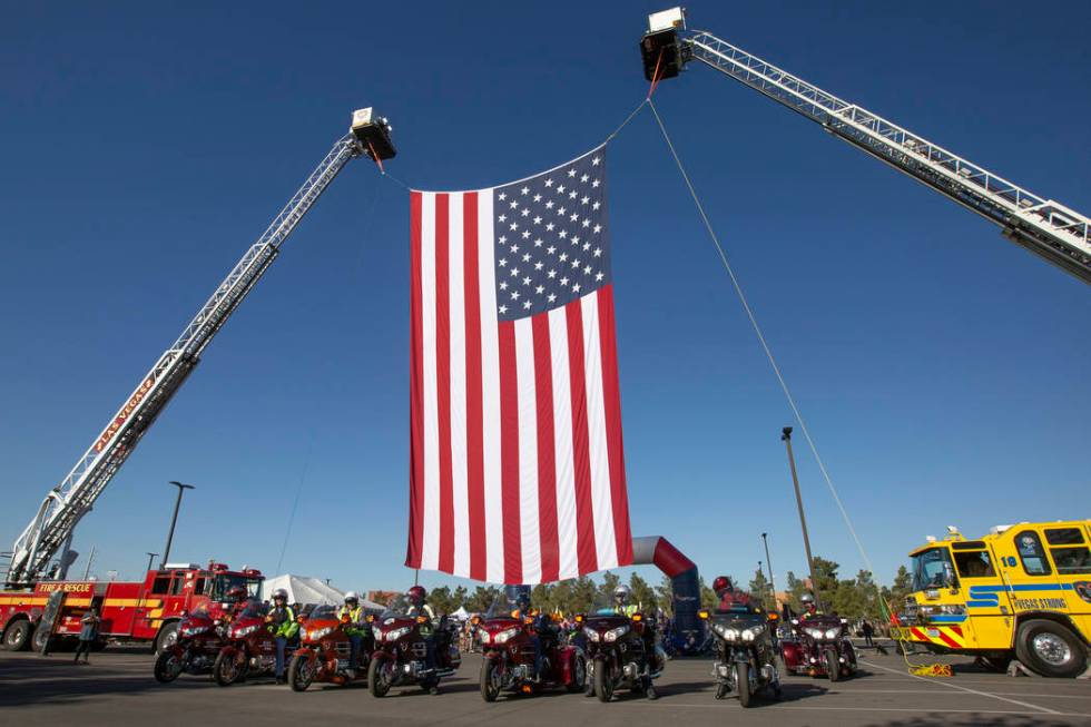 The American flag is hung for Las Vegas Honor Ride participants to ride under on Saturday, Nov. ...