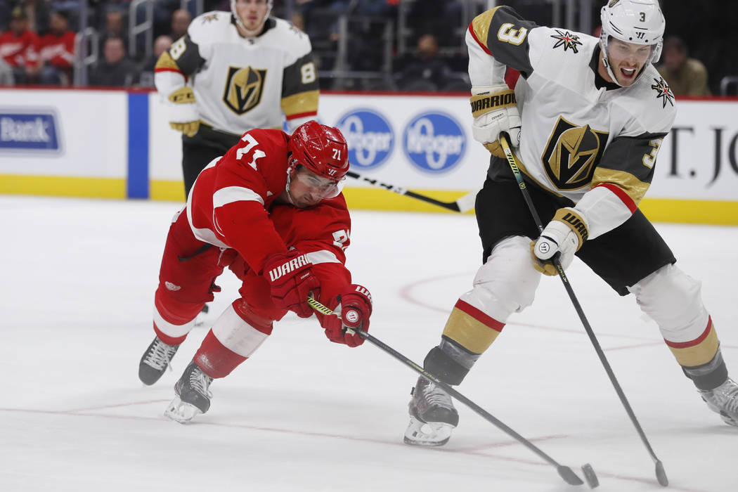 Detroit Red Wings center Dylan Larkin (71) reaches for the puck next to Vegas Golden Knights de ...