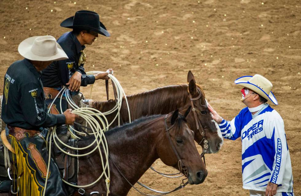 Rodeo clown Flint Rasmussen, right, jokes around with safety man Derrick Begay, top left, durin ...