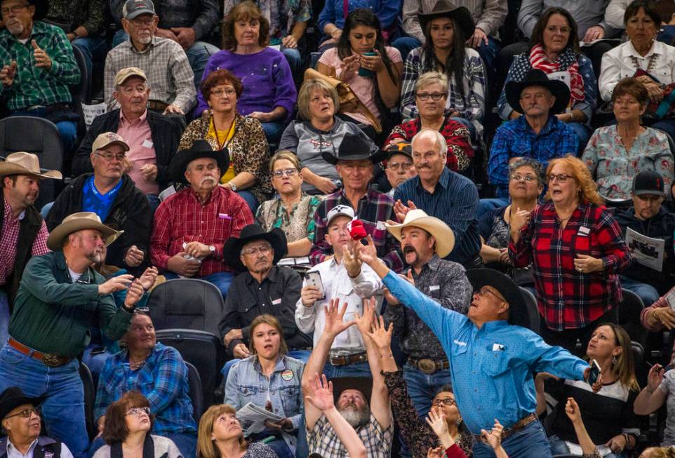 Fans reach for a free t-shirt tossed in to the crowd during the last day of the PBR World Final ...