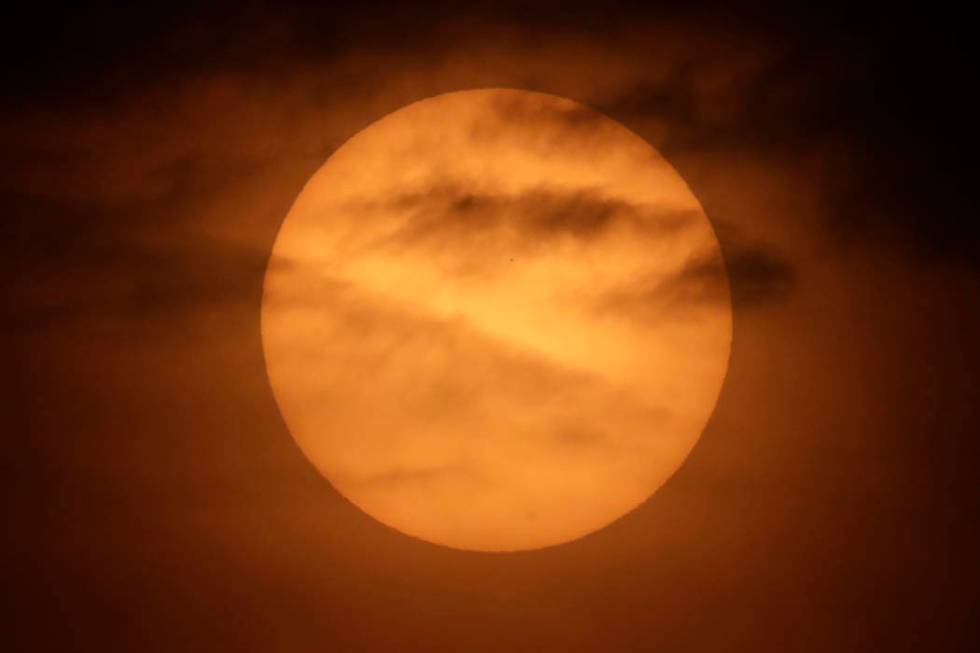 The planet Mercury is seen as a tiny dot above the mid-point of the sun during a transit across ...