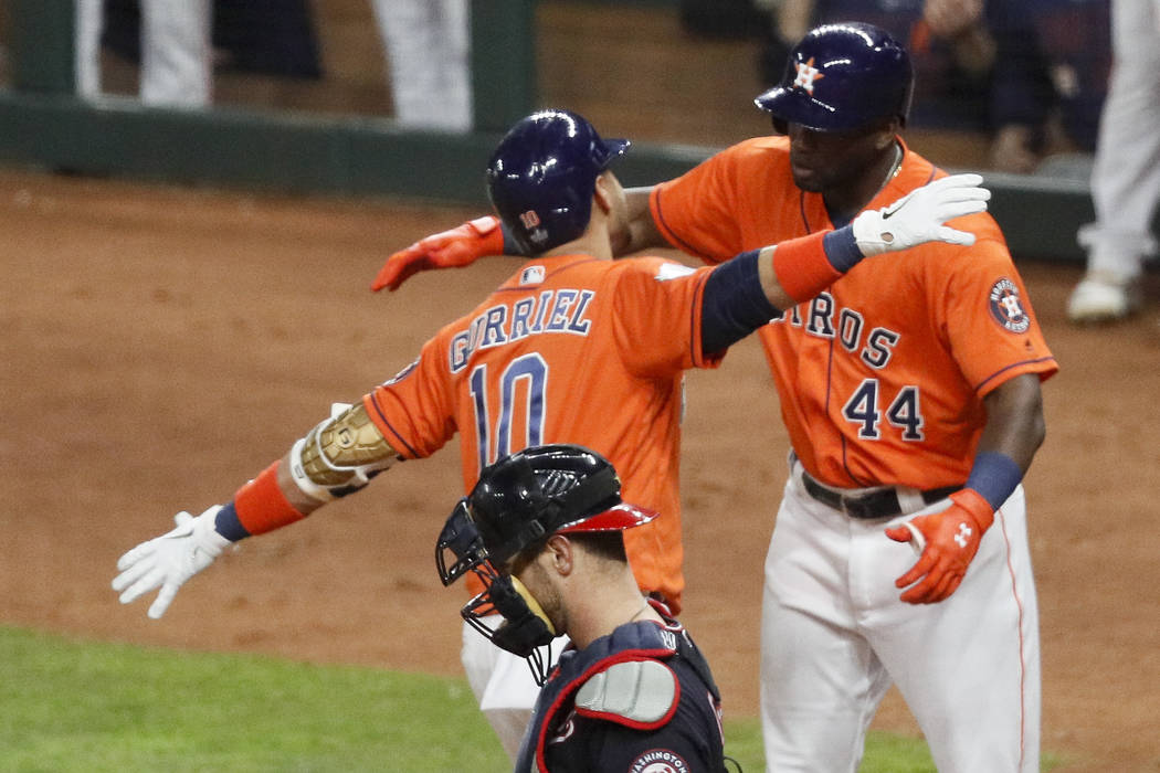 Houston Astros' Yuli Gurriel (10) celebrates with Yordan Alvarez past Washington Nationals catc ...