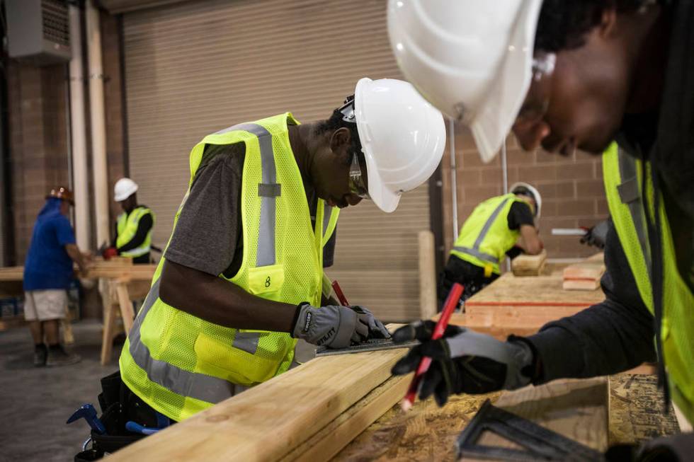 Tayvon Jenkins takes measurements in a framing class for homeless youth as part of HomeAid WORK ...