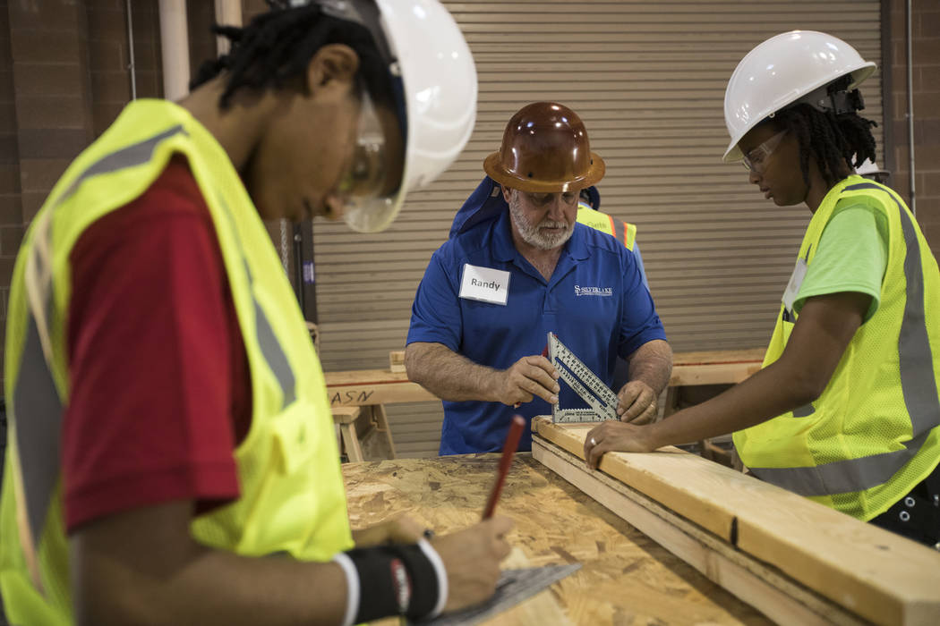 Randy Griebel, center, helps students and sisters Tamira Williams, left, and Alex Coulter, righ ...