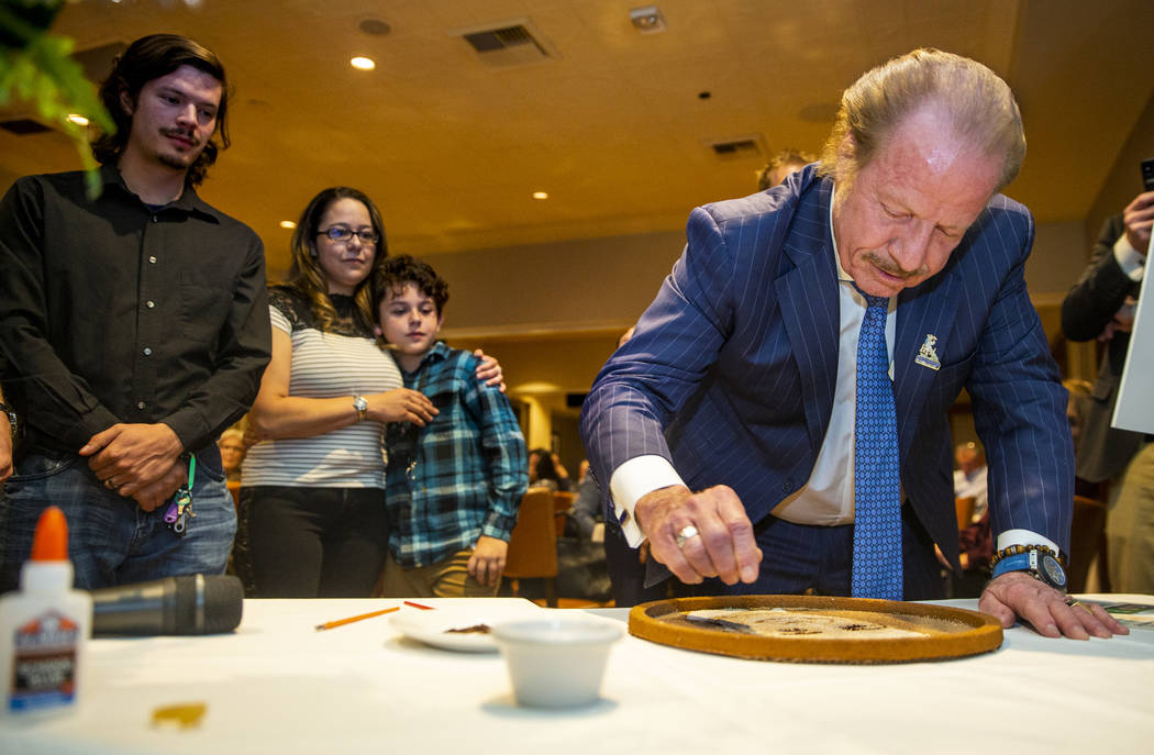 Jim Jimmerson adds flower seeds to a floragraph of his son Jacob Jimmerson who is being honored ...