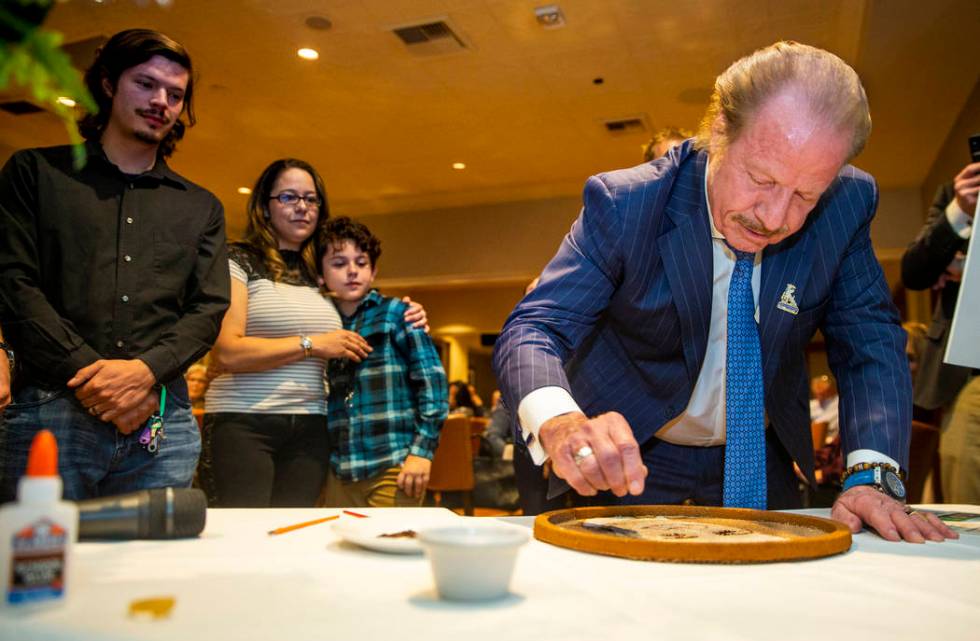 Jim Jimmerson adds flower seeds to a floragraph of his son Jacob Jimmerson who is being honored ...