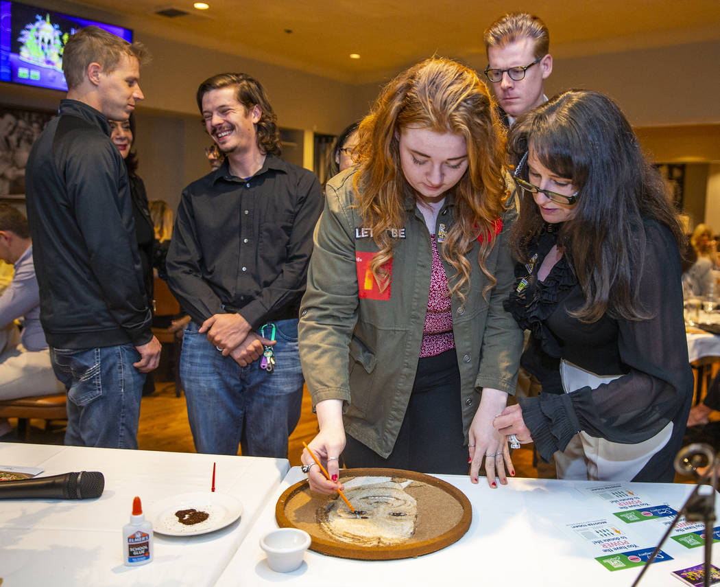 Bentley, left, and Carol Jimmerson add flower seeds to a floragraph of family member Jacob Jimm ...