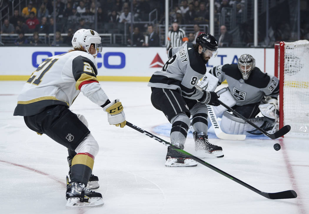 Los Angeles Kings defenseman Drew Doughty, center, chases down the puck past Vegas Golden Knigh ...