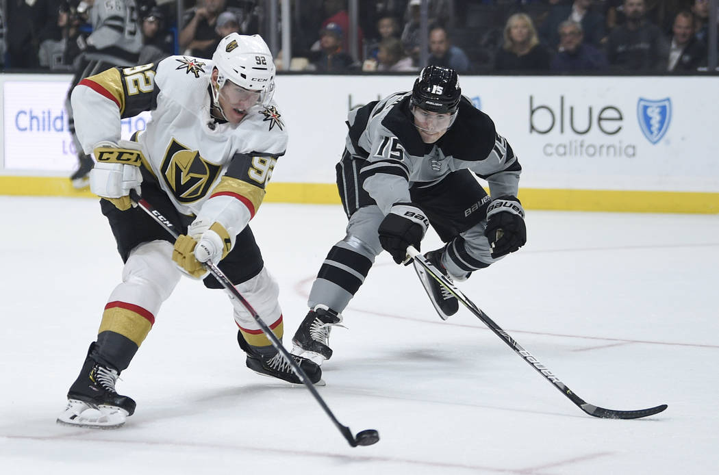 Vegas Golden Knights center Tomas Nosek, left, shoots the puck while pursued by Los Angeles Kin ...