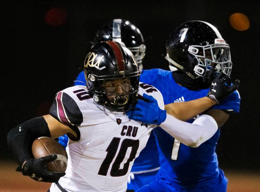 Faith Lutheran junior running back Amani El-Nawal (10) stiff arms Desert Pines senior defensive ...