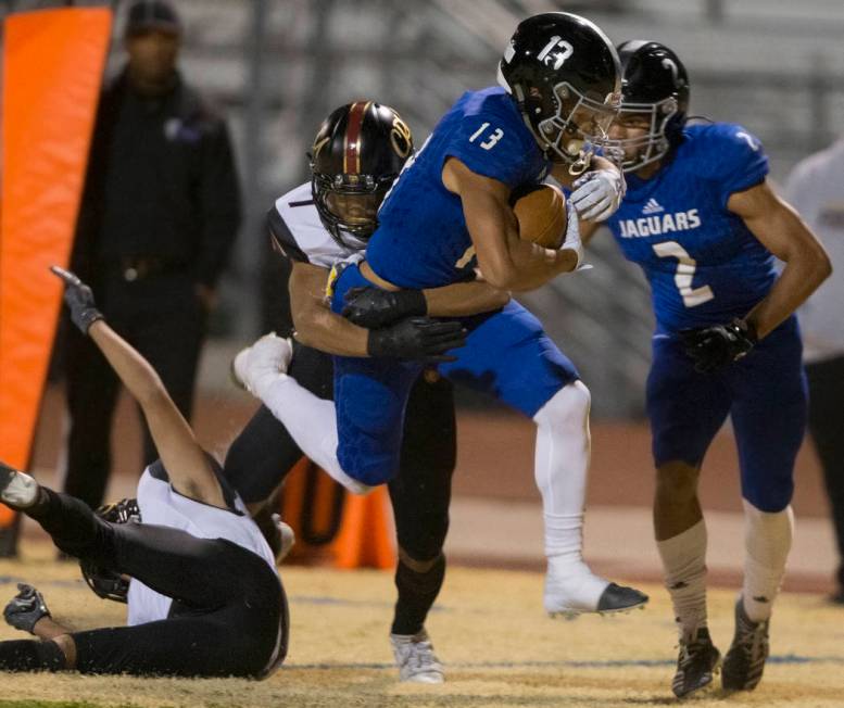 Desert Pines junior wide receiver Michael Jackson (13) leaps towards the goal line with Faith L ...