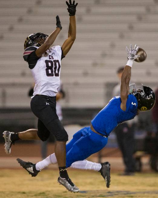 Desert Pines senior defensive back Darius Stewart (5) leaps to try and make an interception ove ...