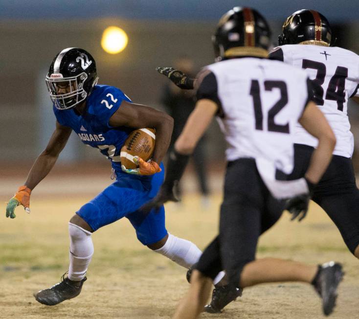 Desert Pines sophomore running back Javontae Barnes (22) cuts up field past Faith Lutheran seni ...