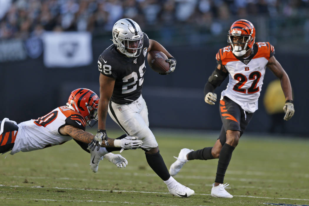 Oakland Raiders running back Josh Jacobs runs with the ball away from Cincinnati Bengals free s ...