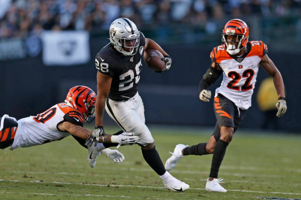 Oakland Raiders running back Josh Jacobs runs with the ball away from Cincinnati Bengals free s ...