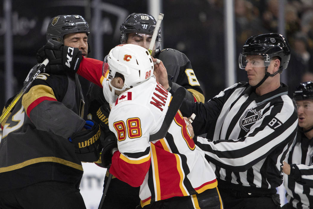 Golden Knights defenseman Deryk Engelland (5) takes a punch from Calgary Flames left wing Andre ...