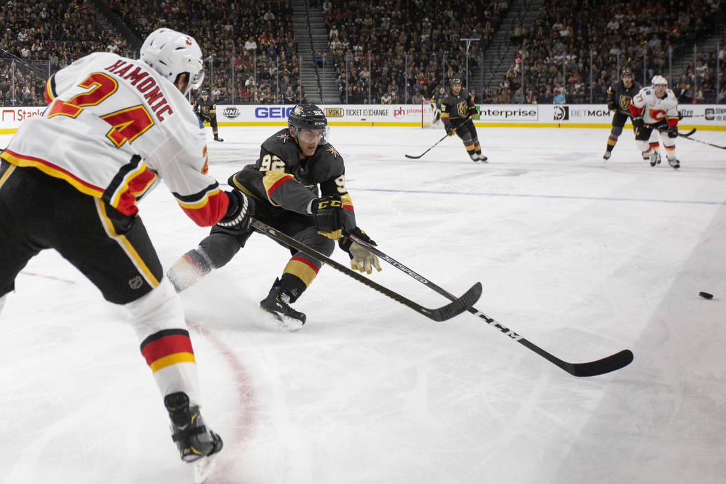 Golden Knights left wing Tomas Nosek (92) goes for the puck against Calgary Flames defenseman T ...