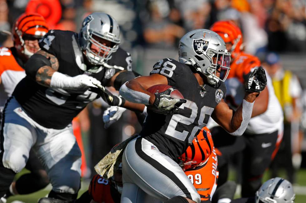 Oakland Raiders quarterback Derek Carr (4) leaps with the ball over the goal line to score a to ...