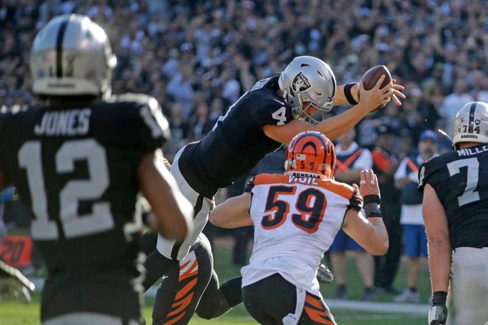 Oakland Raiders quarterback Derek Carr (4) leaps with the ball over the goal line to score a to ...