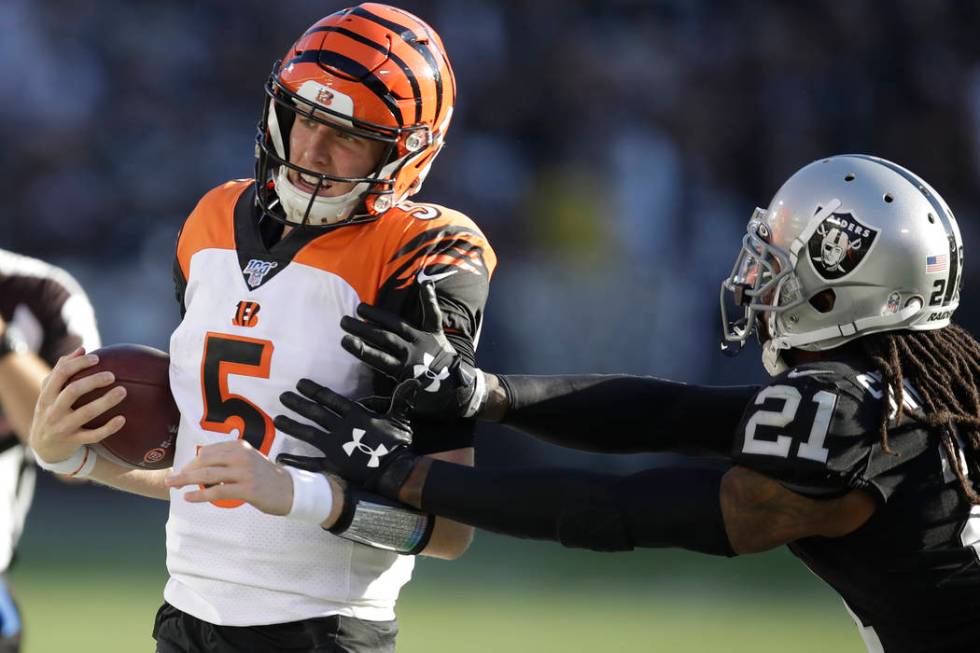 Cincinnati Bengals quarterback Ryan Finley is knocked out of bounds by Oakland Raiders free saf ...