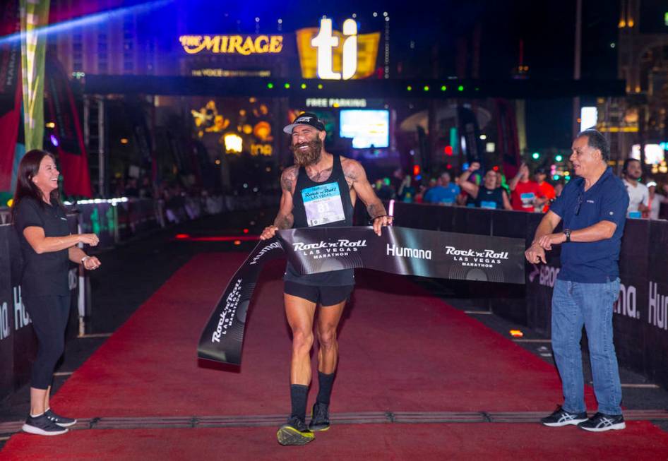 Men's marathon winner Tommy Puzey crosses the finish line during the Las Vegas Rock 'n' Roll Ma ...