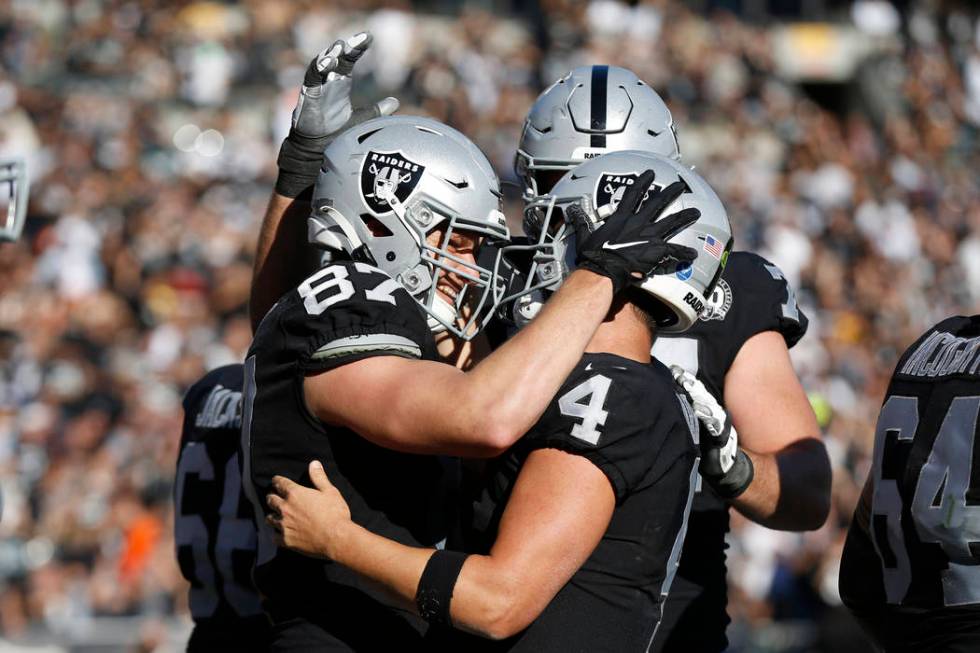 Oakland Raiders tight end Foster Moreau (87) is greeted by quarterback Derek Carr (4) after sco ...