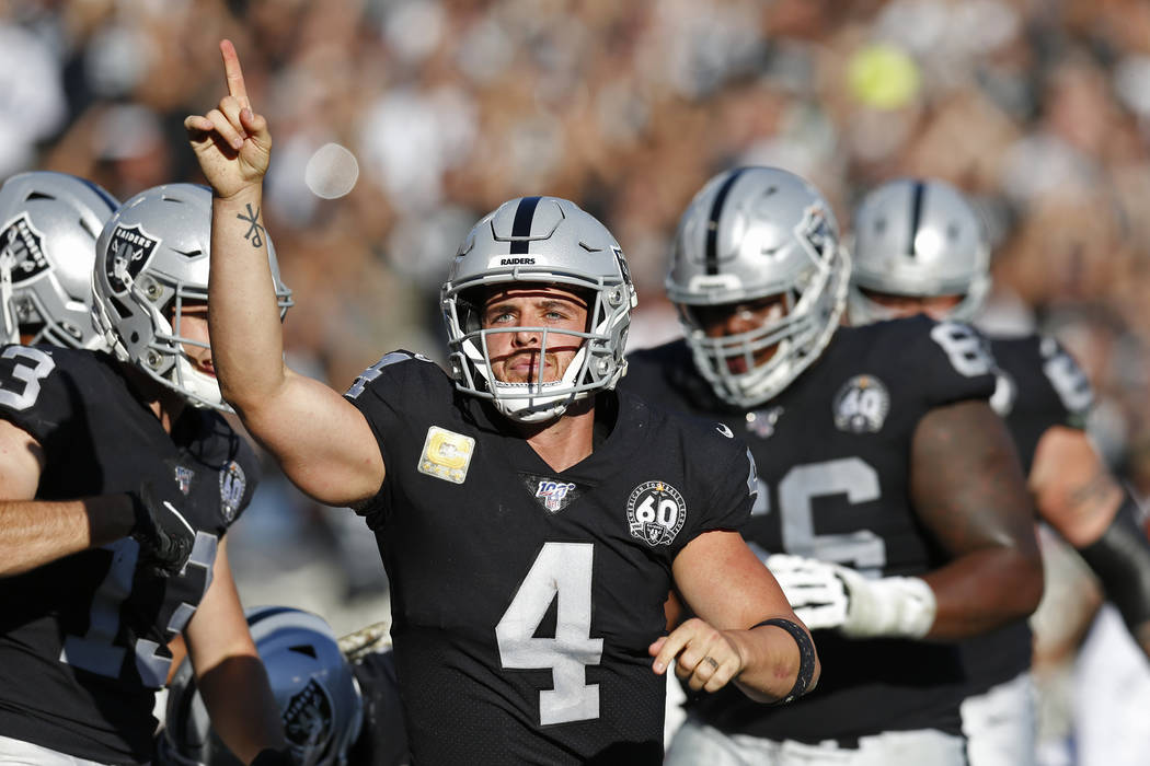 Oakland Raiders quarterback Derek Carr celebrates after scoring a touchdown during the first ha ...